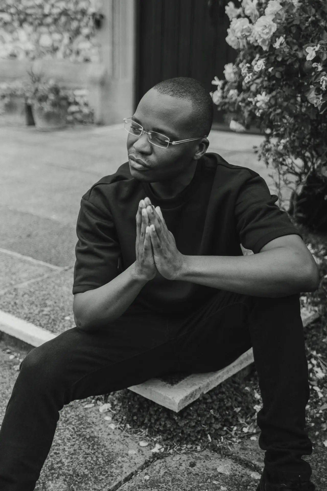 Tobi Tokz with his hands together outside a church